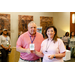 A woman in a pink shirt holding up a Starbucks gift card with a man in a pink polo.